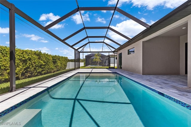 view of swimming pool with a lanai and a patio