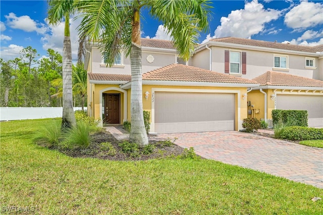 mediterranean / spanish house with a front yard and a garage