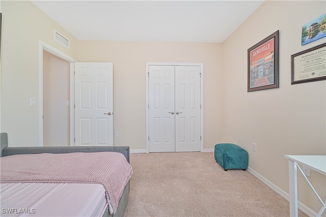 bedroom featuring a closet and light colored carpet