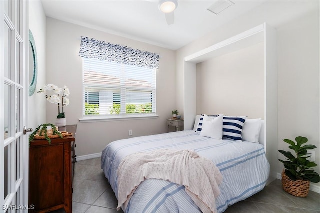 bedroom with ceiling fan and light tile patterned floors