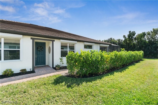 property entrance with a lawn