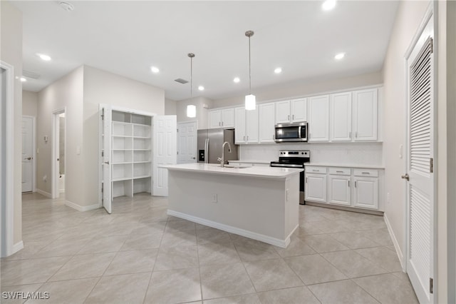 kitchen featuring sink, white cabinetry, hanging light fixtures, a center island with sink, and appliances with stainless steel finishes