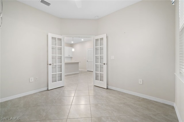 unfurnished room featuring light tile patterned floors and french doors