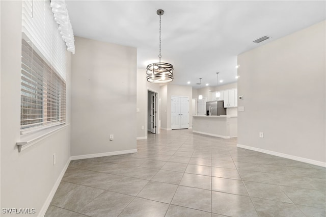 unfurnished living room featuring light tile patterned floors and a chandelier