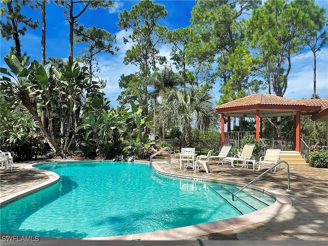 community pool featuring a patio area, fence, and a gazebo