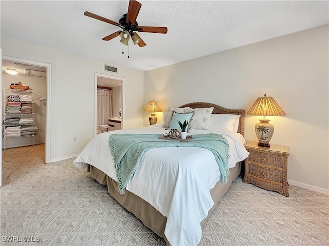 bedroom with visible vents, light carpet, baseboards, and a spacious closet