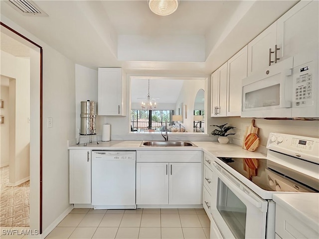 kitchen featuring white appliances, a sink, visible vents, white cabinetry, and light countertops