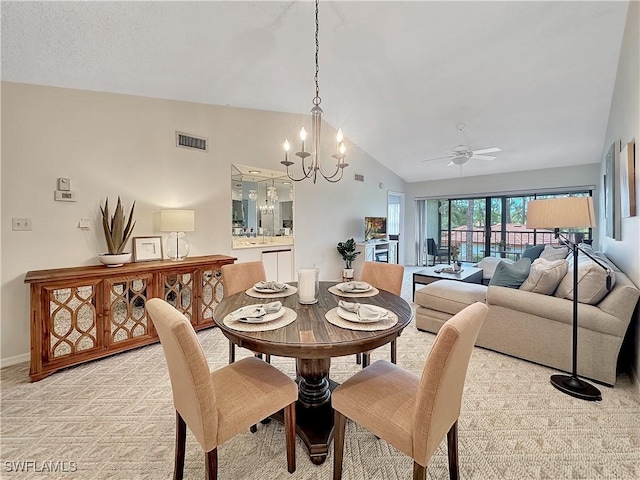 dining room with lofted ceiling, ceiling fan with notable chandelier, light carpet, visible vents, and baseboards