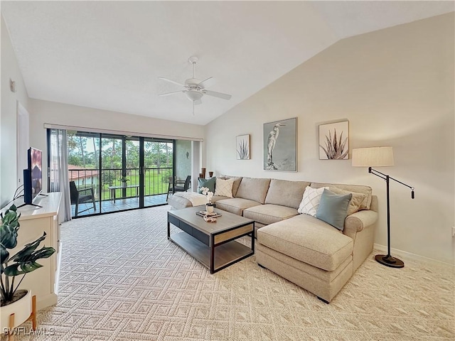 living room featuring a ceiling fan, light carpet, vaulted ceiling, and baseboards