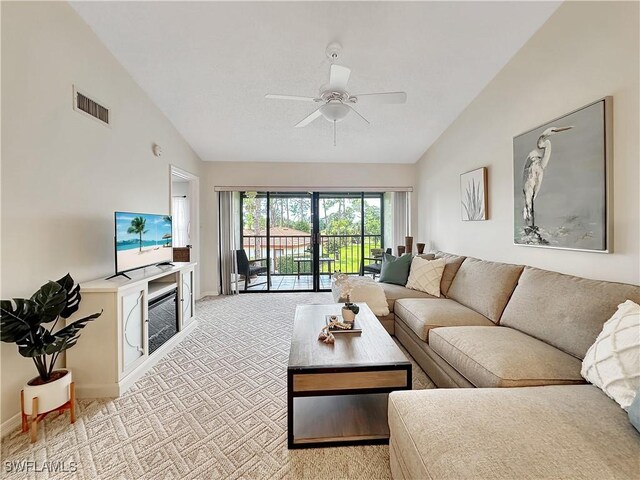 living area featuring light colored carpet, visible vents, ceiling fan, high vaulted ceiling, and baseboards