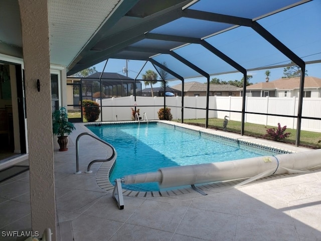 view of pool with glass enclosure and a patio