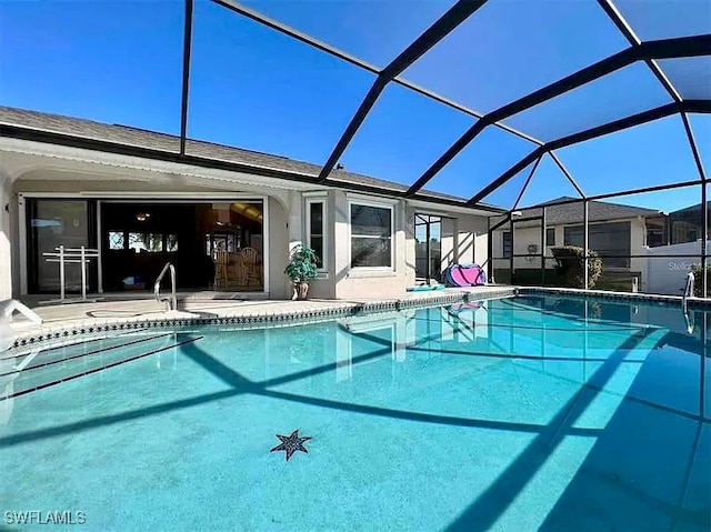 view of pool with a patio area and glass enclosure