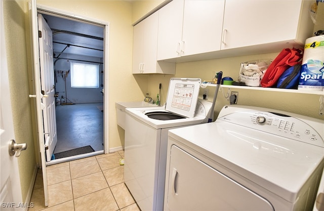 laundry room featuring light tile patterned floors, cabinets, and washer and dryer