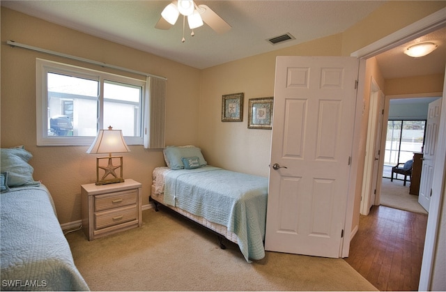 bedroom featuring light wood-type flooring, multiple windows, and ceiling fan