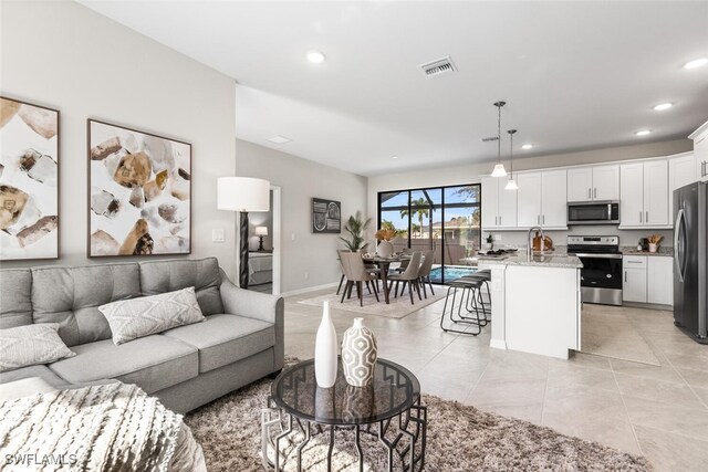 living room with light tile patterned floors, baseboards, visible vents, and recessed lighting