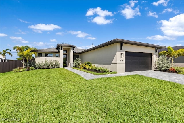 view of front of property with decorative driveway, stucco siding, an attached garage, fence, and a front lawn