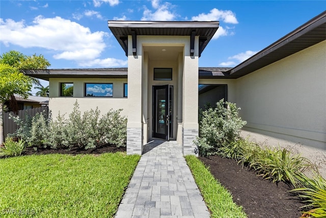 property entrance with stone siding and stucco siding