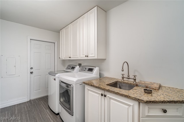 washroom featuring dark wood-type flooring, washer and clothes dryer, sink, and cabinets