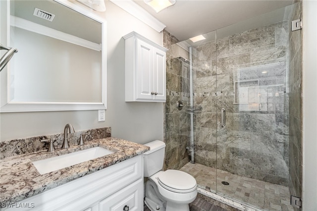 bathroom featuring a shower with shower door, toilet, and vanity