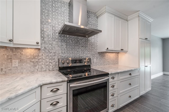 kitchen with stainless steel electric range oven, white cabinetry, and wall chimney range hood