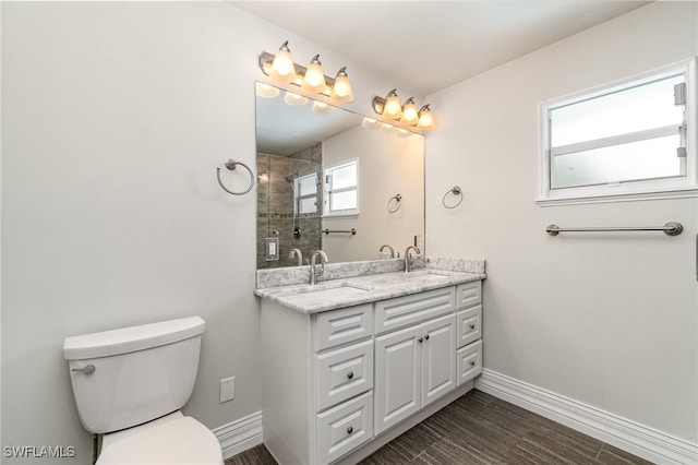 bathroom featuring tiled shower, vanity, toilet, and hardwood / wood-style flooring