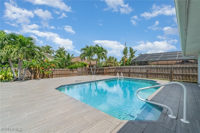 view of swimming pool with a lanai and a patio area