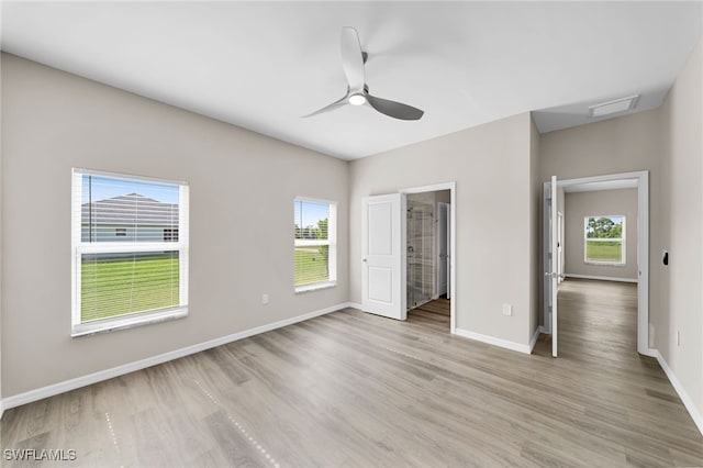 unfurnished bedroom featuring light hardwood / wood-style flooring, ceiling fan, a spacious closet, and multiple windows