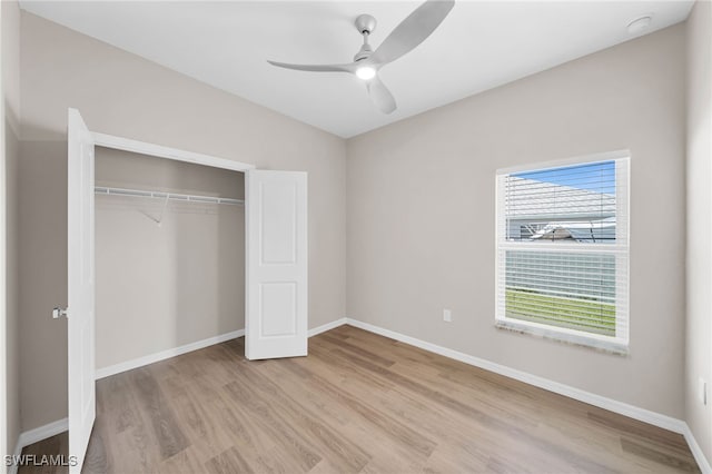 unfurnished bedroom featuring light hardwood / wood-style flooring, ceiling fan, and a closet