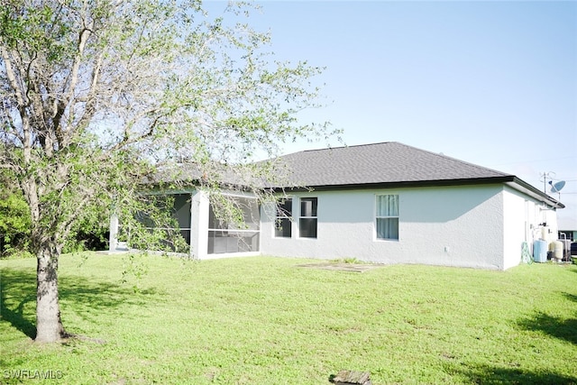 rear view of house featuring a lawn