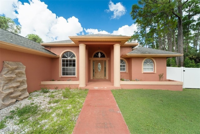 view of exterior entry featuring a yard