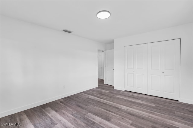 unfurnished bedroom with a closet and hardwood / wood-style floors