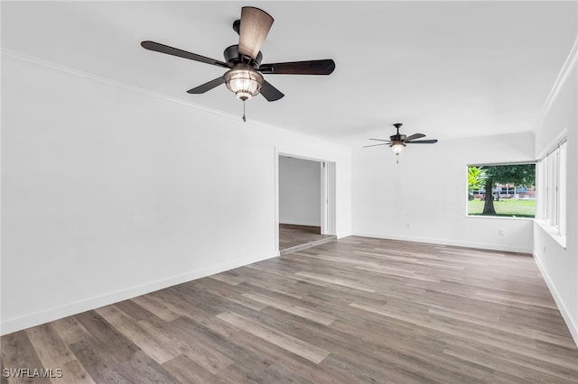 unfurnished room featuring ornamental molding, light wood-type flooring, and ceiling fan