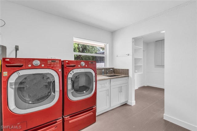 washroom featuring separate washer and dryer, sink, and cabinets