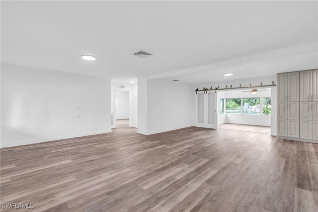 unfurnished living room with light wood-type flooring and ceiling fan