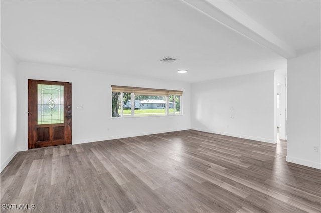 unfurnished living room with wood-type flooring and beam ceiling