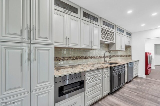 55 Aqua Ln, North Fort Myers, FL 33903 - kitchen with light wood-type flooring, a sink, light stone counters, backsplash, and appliances with stainless steel finishes