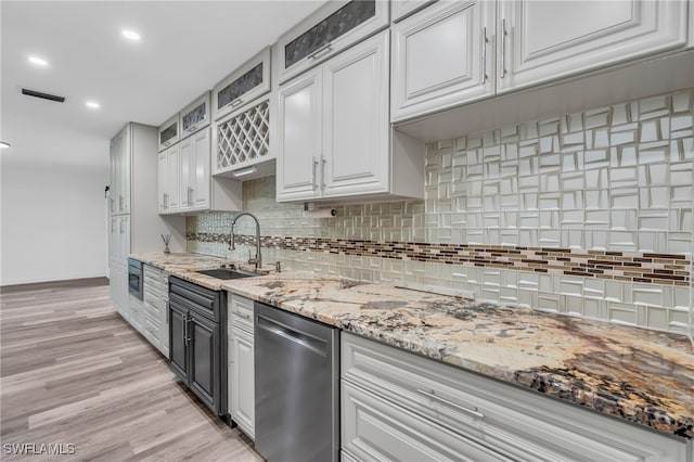 kitchen featuring light wood-type flooring, sink, dishwasher, backsplash, and white cabinetry