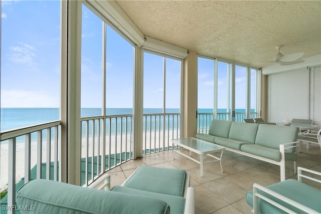 sunroom / solarium with a water view, ceiling fan, and plenty of natural light