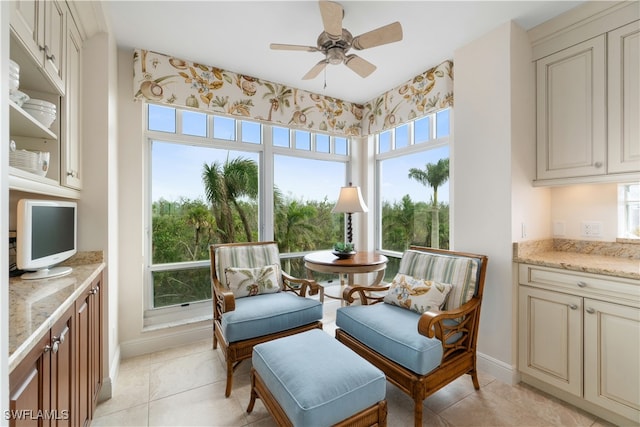 living area with ceiling fan and light tile patterned floors