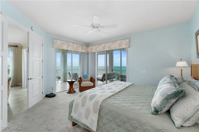 carpeted bedroom featuring a water view, ceiling fan, and access to exterior