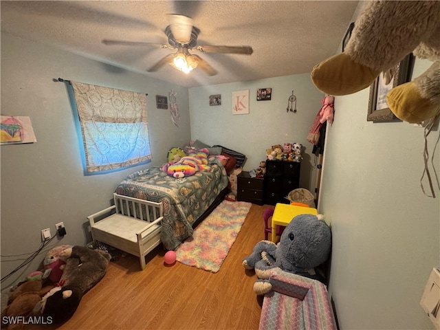 bedroom featuring hardwood / wood-style floors, a textured ceiling, and ceiling fan