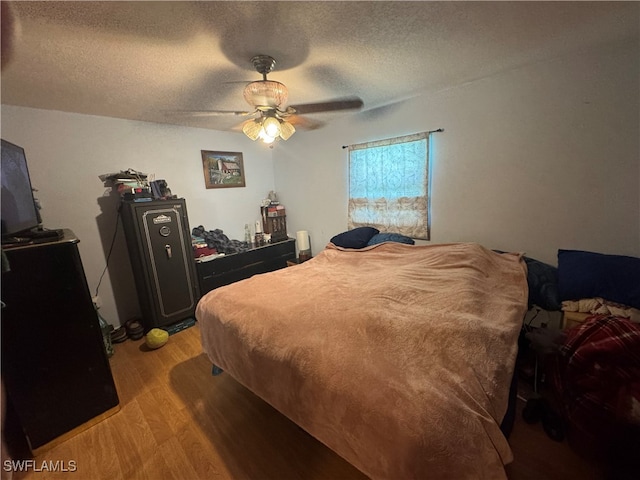 bedroom with ceiling fan, a textured ceiling, and light hardwood / wood-style flooring