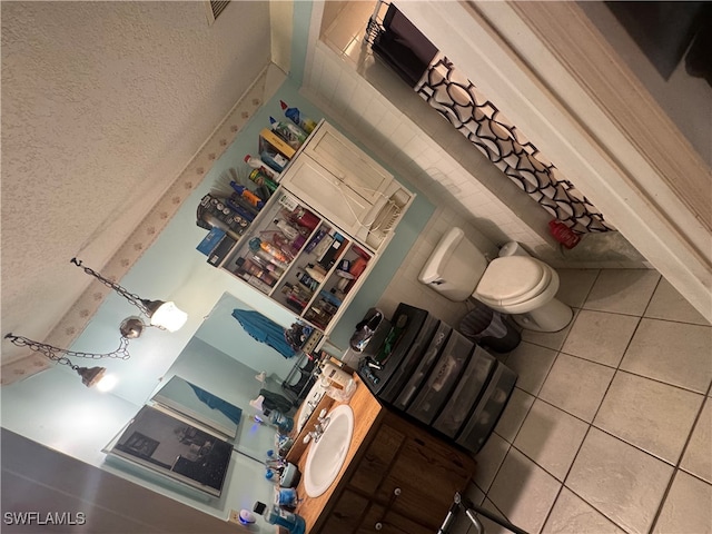 bathroom featuring vanity, tile patterned floors, a notable chandelier, and toilet