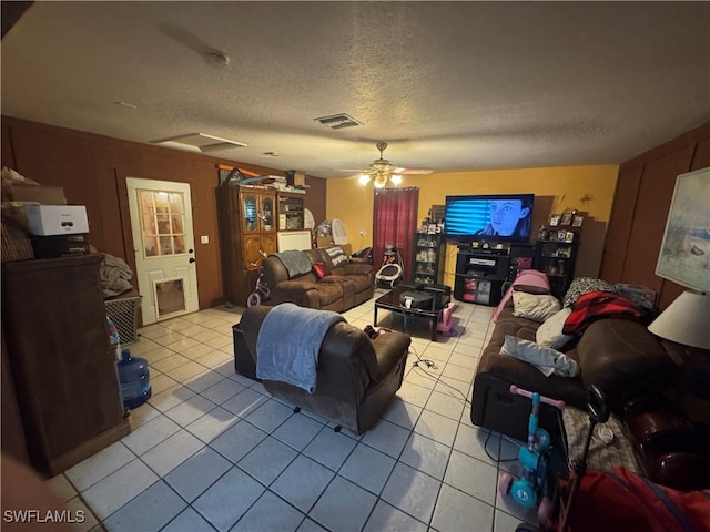 living room with a textured ceiling, light tile patterned floors, and ceiling fan