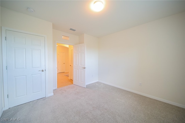 unfurnished bedroom featuring light carpet