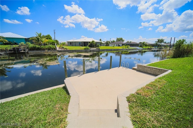 dock area with a lawn and a water view