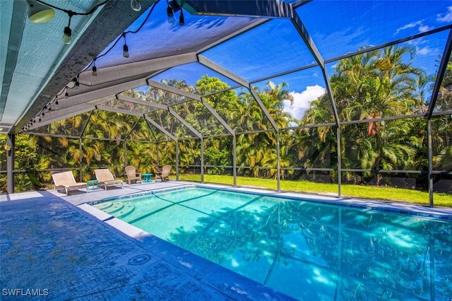 view of swimming pool featuring glass enclosure and a patio