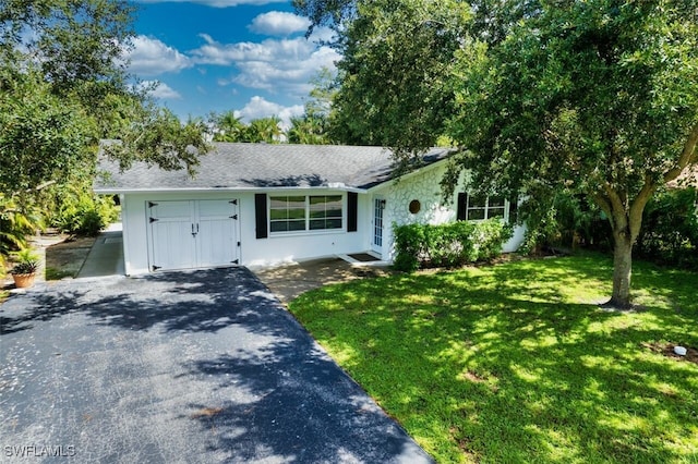 ranch-style house with a garage and a front yard