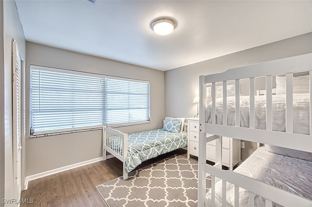 bedroom with multiple windows and hardwood / wood-style flooring