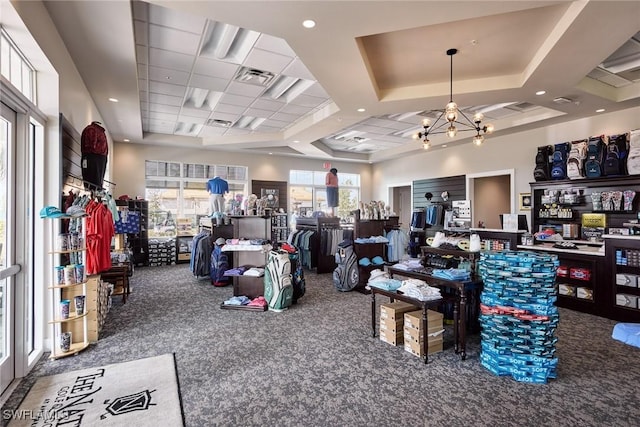 misc room with a tray ceiling, a chandelier, and carpet flooring